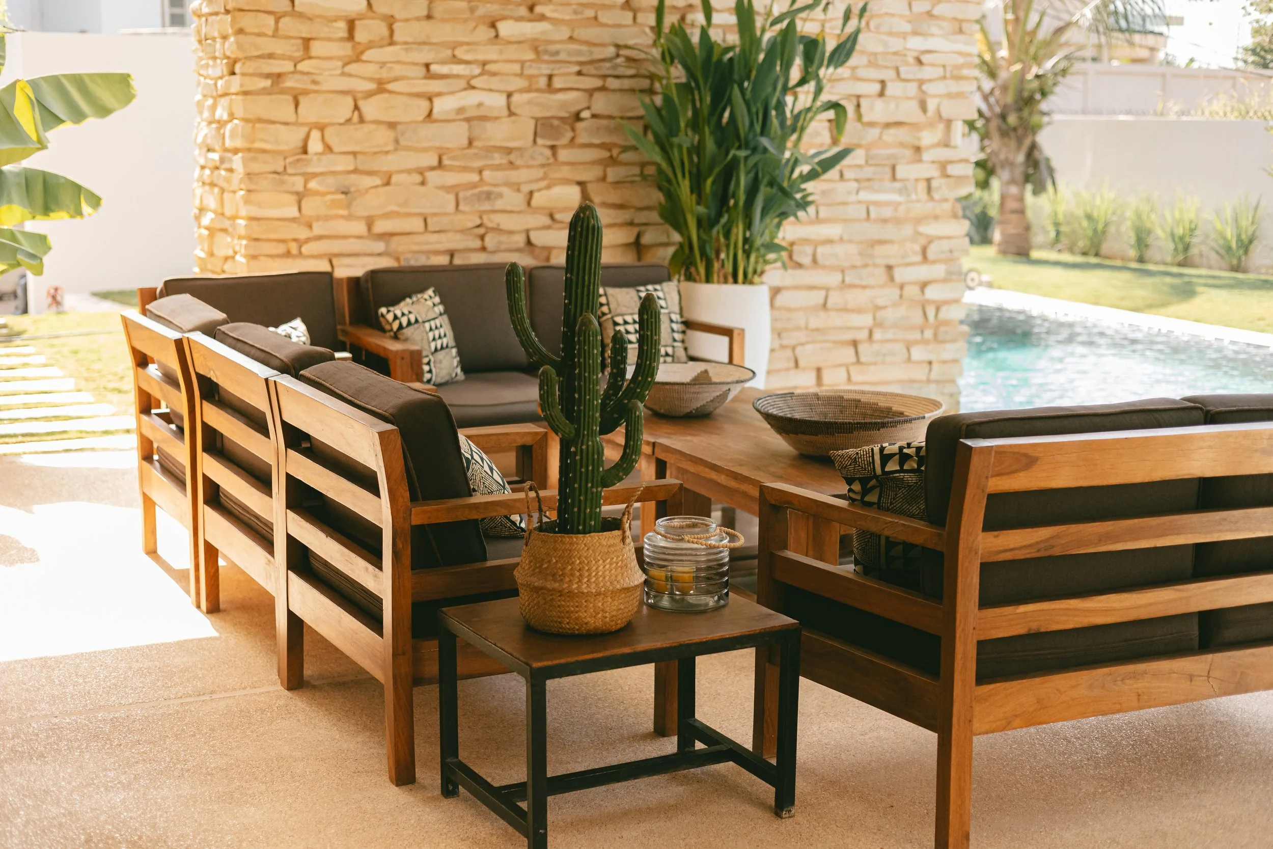 Lounge extérieur avec cactus et plantes, piscine en arrière-plan