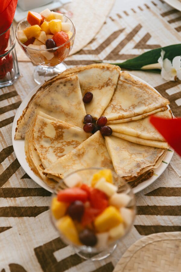 Crêpes faites maison de Rose et coupelles de salade de fruits sur nappe africaine