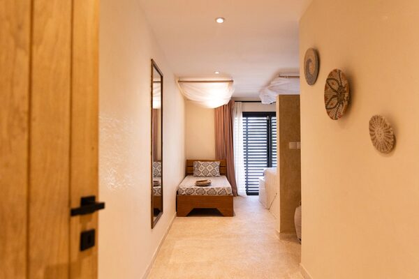 Suite avec grand lit double, miroir et tenture africaine