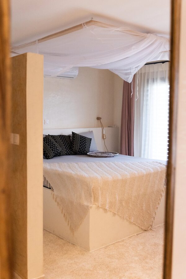 Suite avec lit baldaquin et moustiquaire, ambiance tropicale